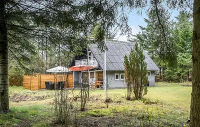 a house in the middle of a yard with trees at 2 Bedroom Gorgeous Home In Saltum in Saltum