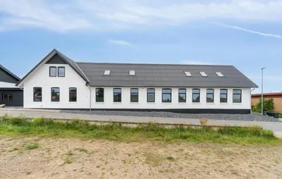 a white building with a black roof at Nice Home In Spøttrup With Sauna in Spottrup