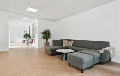 a living room with a couch and a table and chairs at Nice Home In Spøttrup With Sauna in Spottrup