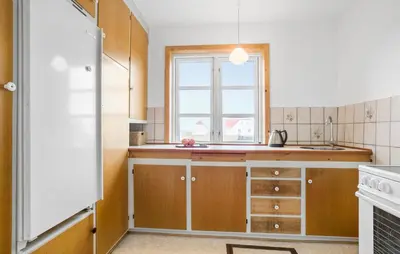 a kitchen with wooden cabinets and a window at 3 Bedroom Pet Friendly Home In Frøstrup in Frøstrup