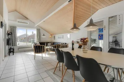 a kitchen and dining room with a table and chairs at Cozy holiday house with pool by the sea - SJ940 in Harboør