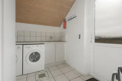a white laundry room with a washer and dryer at Cozy holiday house with pool by the sea - SJ940 in Harboør