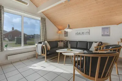 a living room with a couch and a table at Cozy holiday house with pool by the sea - SJ940 in Harboør
