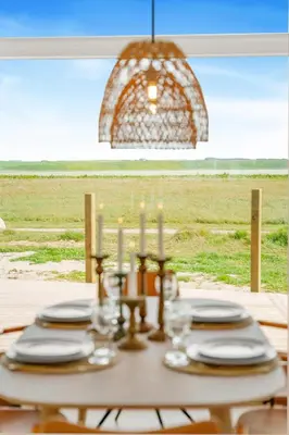 a table with plates and candles on top of it at Uniquely located wooden cottage by the sea - SJ1 in Harboør