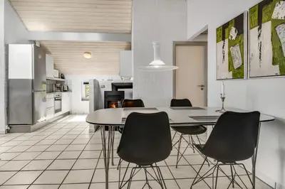 a kitchen with a dining room table and chairs at Holiday home with spa and pool by the sea - SJ670 in Harboør