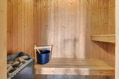 a sauna with a trash can and a bucket at Holiday home with spa and pool by the sea - SJ670 in Harboør
