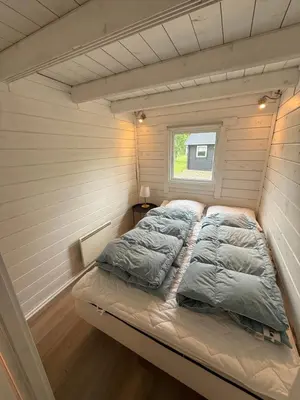 a bed in a small room in a tiny house at Himmerland camping & Feriecenter in Års