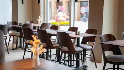 a row of tables and chairs in a restaurant at Hotel Nørreport in Holstebro