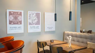 a dining room with a table and chairs and a couch at Hotel Nørreport in Holstebro
