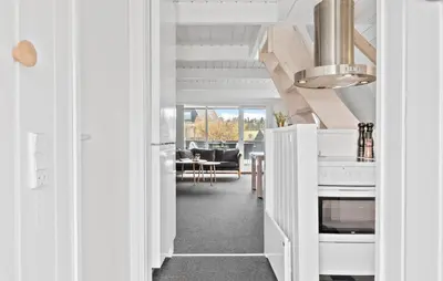 a kitchen with white cabinets and a living room at Awesome Home In Farsø With Wifi in Farsø