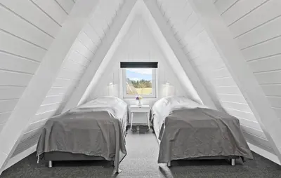 two beds in a attic room with a window at Awesome Home In Farsø With Wifi in Farsø