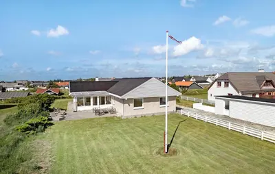 a white house with a flag pole in a yard at Beautiful Home In Thisted With Wifi in Thisted