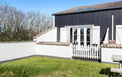 a black and white house with a white fence at Amazing Apartment In Vestervig in Vestervig
