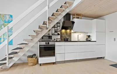 a kitchen with white cabinets and a staircase at Amazing Apartment In Vestervig in Vestervig