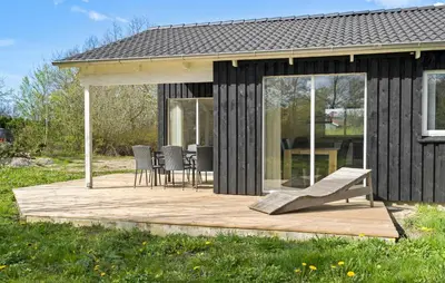a cabin with a wooden deck with a table and chairs at 4 Bedroom Nice Home In Vinderup in Vinderup