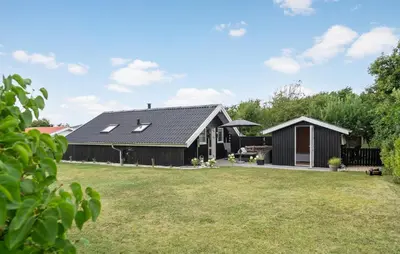 a house with a black roof and a yard at Cozy Home In Vestervig With Wifi in Vestervig