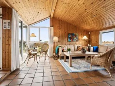 a living room with wooden walls and a wooden ceiling at Holiday Home Dolores - 200m from the sea by Interhome in Torsted