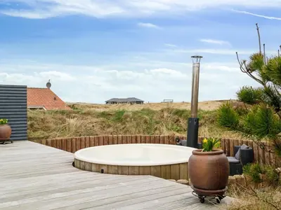 a hot tub on a wooden deck next to a fence at Holiday Home Dolores - 200m from the sea by Interhome in Torsted