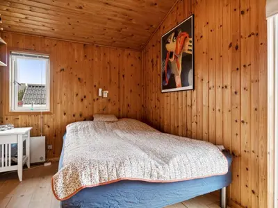 a bedroom with a bed in a room with wooden walls at Holiday Home Dolores - 200m from the sea by Interhome in Torsted