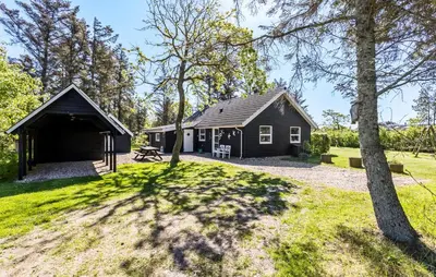 a black house in the middle of a yard at 3 Bedroom Amazing Home In Vestervig in Vestervig