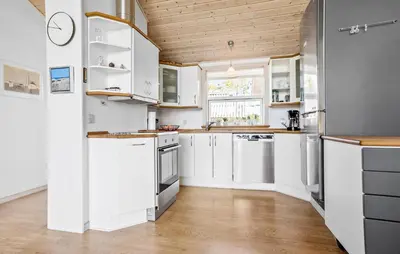 a kitchen with white cabinets and a wooden ceiling at 3 Bedroom Amazing Home In Vestervig in Vestervig