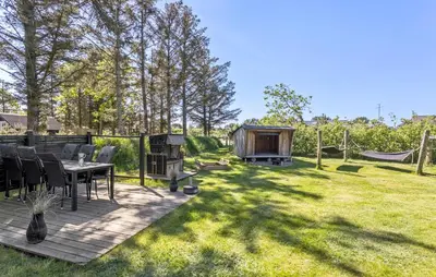 a backyard with a table and chairs and a wooden deck at 3 Bedroom Amazing Home In Vestervig in Vestervig