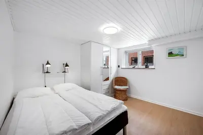 a white bedroom with a large bed in it at Nyd den skønne natur ved hav og fjord in Thyborøn