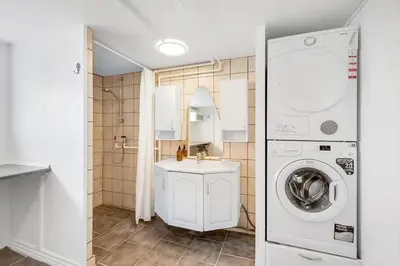 a bathroom with a sink and a washing machine at Nyd den skønne natur ved hav og fjord in Thyborøn
