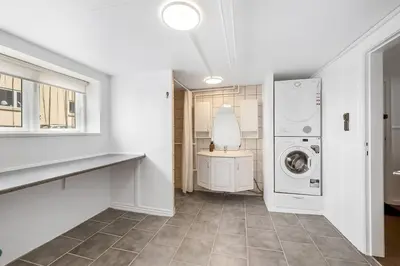 a white laundry room with a washer and dryer at Nyd den skønne natur ved hav og fjord in Thyborøn