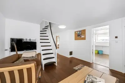 a living room with a couch and a spiral staircase at Nyd den skønne natur ved hav og fjord in Thyborøn