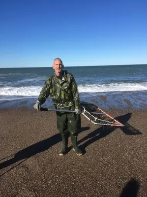 a man standing on the beach holding a kite at Nyd den skønne natur ved hav og fjord in Thyborøn