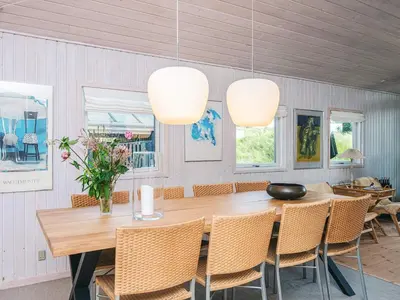 a dining room with a wooden table and chairs at 4 star holiday home in Blokhus-By Traum in Blokhus