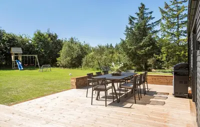 a table and chairs sitting on a patio with a playground at Gorgeous Home In Saltum With Sauna in Saltum