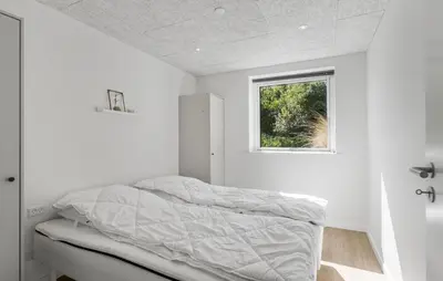 a bed in a white room with a window at Gorgeous Home In Saltum With Sauna in Saltum