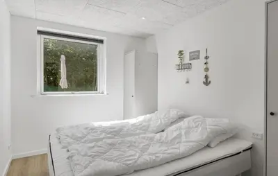 a bed in a white room with a window at Gorgeous Home In Saltum With Sauna in Saltum