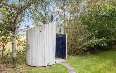 a wooden gate with a blue door in a field at 4 Bedroom Cozy Home In Vestervig in Vestervig