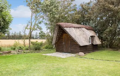 a small house with a grass roof in a field at 4 Bedroom Cozy Home In Vestervig in Vestervig