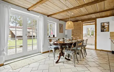 a dining room with a table and chairs and windows at 4 Bedroom Cozy Home In Vestervig in Vestervig
