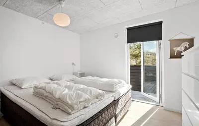 a bedroom with a large bed with white sheets at Stunning Home In Roslev With Kitchen in Roslev