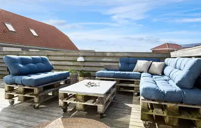 a patio with two blue couches and a coffee table at Lovely Home In Thisted With Sauna in Thisted