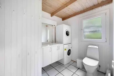 a white bathroom with a toilet and a sink at Pool summerhouse in Saltum near Blokhus in Saltum