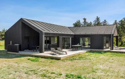 a house with a black roof and a patio at Stunning Home In Saltum With Sauna in Saltum