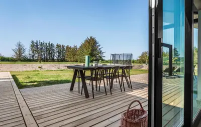a wooden deck with a table and chairs on it at Stunning Home In Saltum With Sauna in Saltum