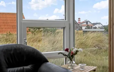 a window with a chair and a vase of flowers on a table at Gorgeous Home In Thisted in Thisted