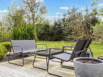 two chairs and a table on a wooden deck at 6 person holiday home in Farsø-By Traum in Farsø