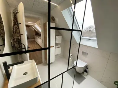 a bathroom with a sink and a toilet and a window at Sunny apartment in Åbybro
