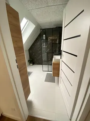 a bathroom with a sink and a sliding door at Sunny apartment in Åbybro