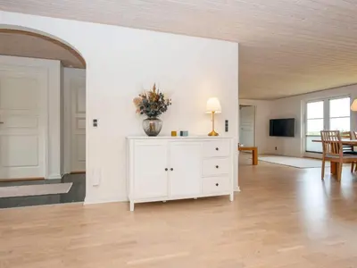 a living room with a vase on a white cabinet at 5 star holiday home in Vinderup-By Traum in Vinderup