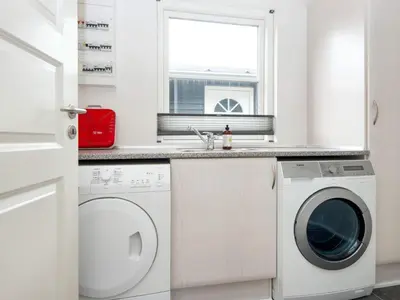 a white laundry room with a washer and dryer at 5 star holiday home in Vinderup-By Traum in Vinderup