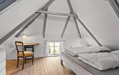 a bedroom with two beds and a desk and a chair at 4 Bedroom Nice Home In Blokhus in Blokhus